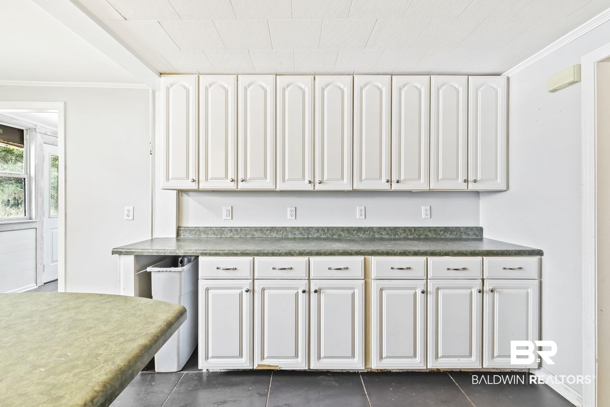 316 West Orchid Avenue Foley, AL 36535 - Photo 30 of 38 Kitchen featuring crown molding, dark countertops, and white cabinetry