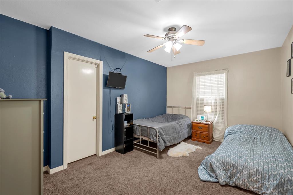 301 North 40th Street Waco, TX 76710 - Photo 15 of 26 Carpeted room with a ceiling fan, a window with blinds and sheer curtains, and a prominent accent wall