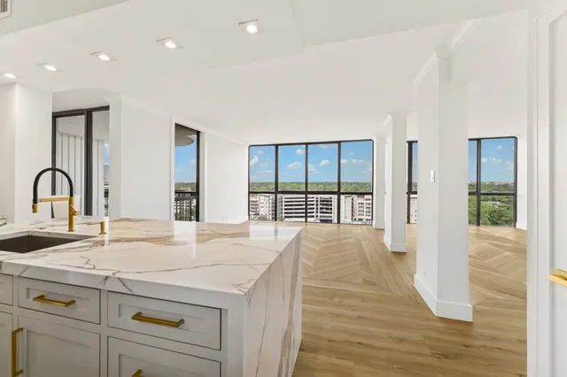 a view of a kitchen with a sink and large window