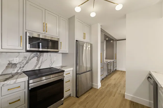 a view of a kitchen with wooden floor and electronic appliances