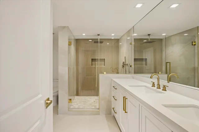 a bathroom with a double vanity sink mirror and shower