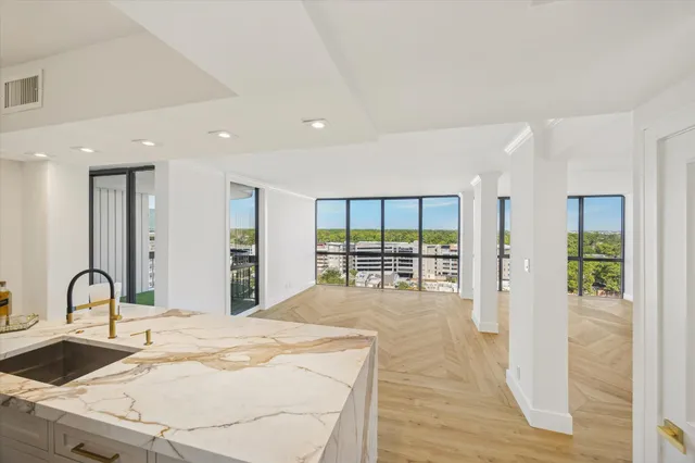 a large white kitchen with a large window and refrigerator