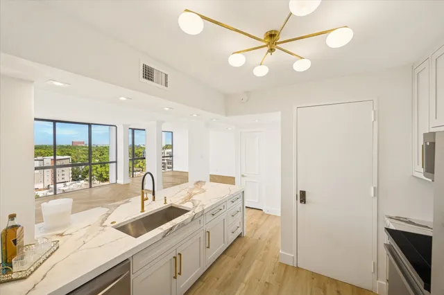 a large white kitchen with wooden floor and a sink