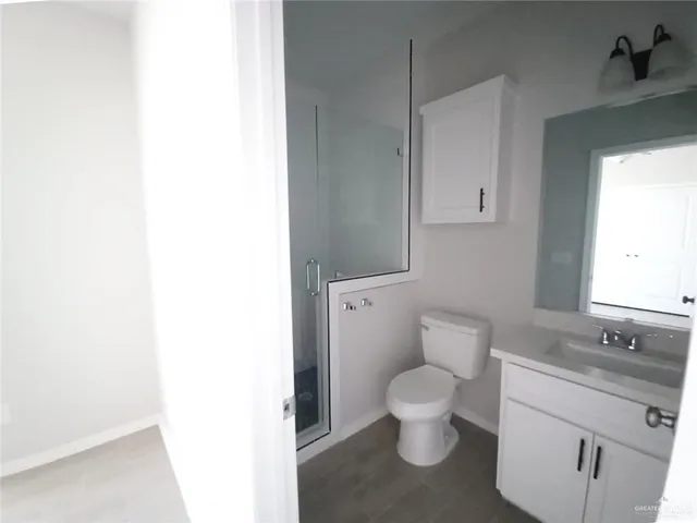 a bathroom with a granite countertop toilet and a sink