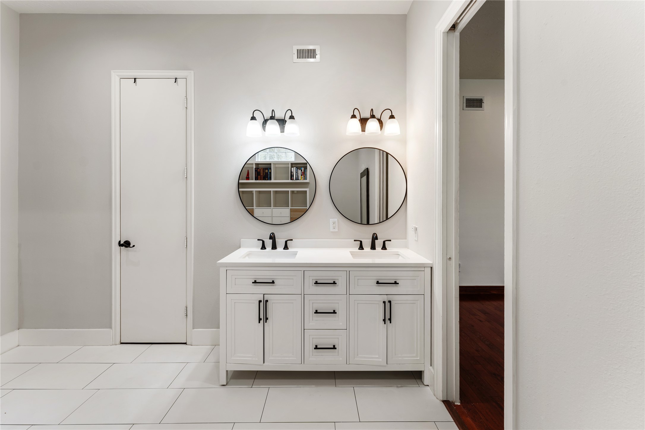 415 West 8th Street Houston, TX 77007 - Photo 12 of 39 The remodeled primary bath showcases dual quartz vanities, designer lighting, and sleek matte black fixtures for a clean, contemporary aesthetic. Abundant storage and premium finishes elevate both form and function. Every detail has been carefully selected to create a refined everyday retreat.