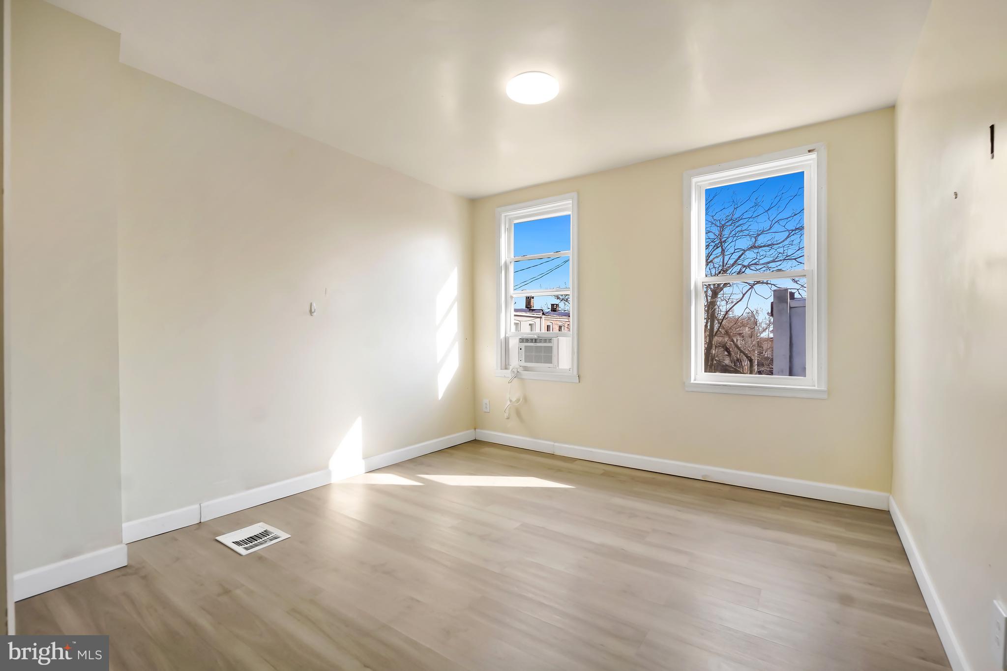 2427 East Lanvale Street Baltimore, MD 21213 - Photo 20 of 29 an empty room with wooden floor and windows