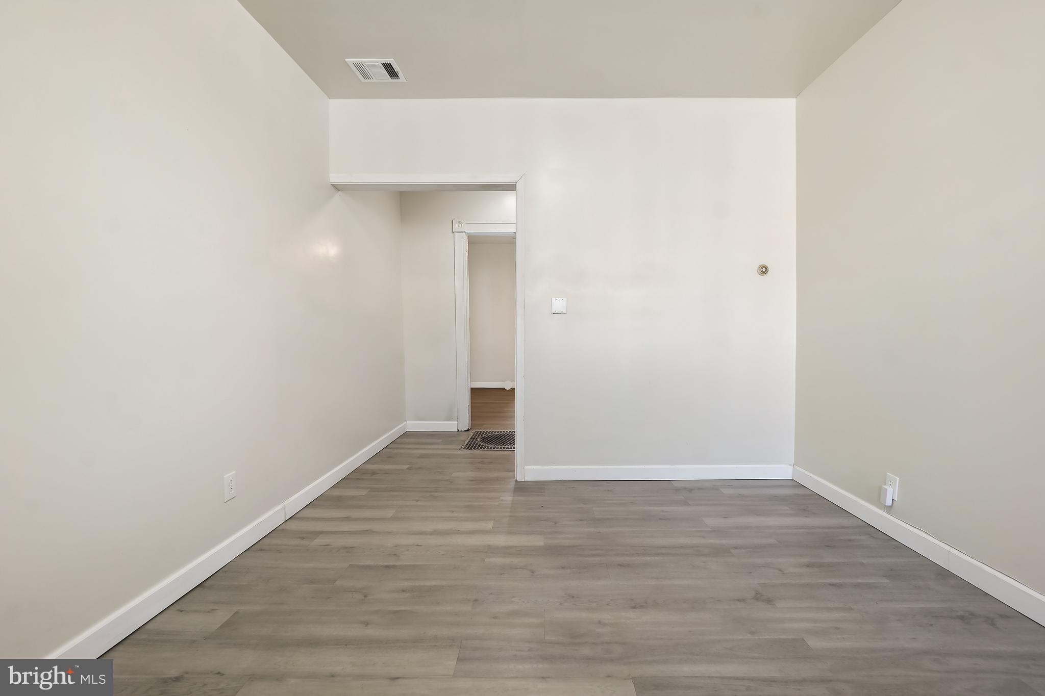 2427 East Lanvale Street Baltimore, MD 21213 - Photo 5 of 29 a view of an empty room with wooden floor