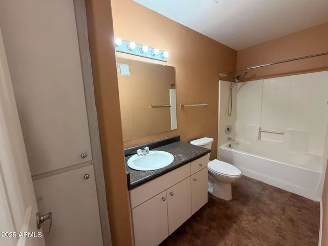 a bathroom with a granite countertop sink toilet a mirror and shower