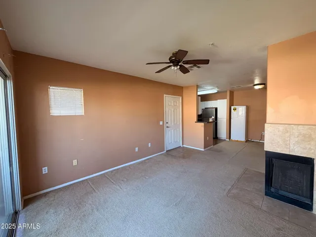 a view of an empty room with a fireplace and a window