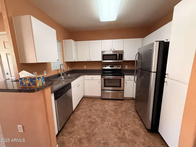 a kitchen with stainless steel appliances a refrigerator stove and sink
