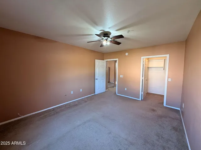 a view of an empty room with a ceiling fan