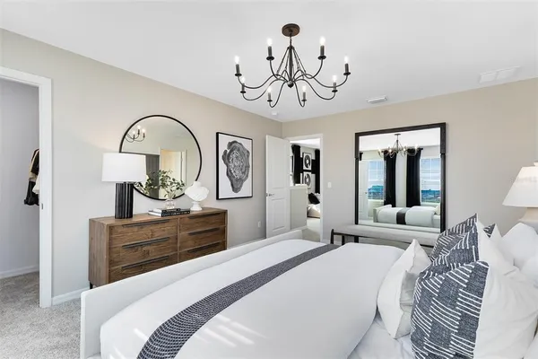 a bedroom with a bed and a chandelier
