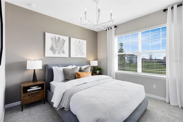 a spacious bedroom with a bed and a large window