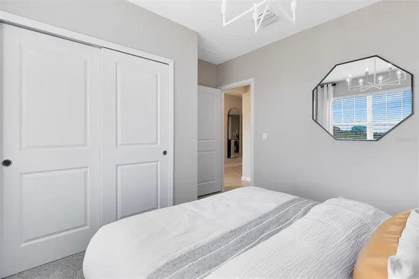 a bedroom with a bed and a mirror