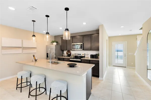 a kitchen with a sink a counter top space appliances and cabinets