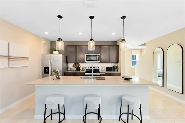 a kitchen with stainless steel appliances granite countertop a kitchen island a stove and a cabinets