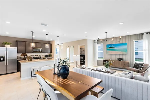 a living room with stainless steel appliances kitchen island furniture and a view of kitchen
