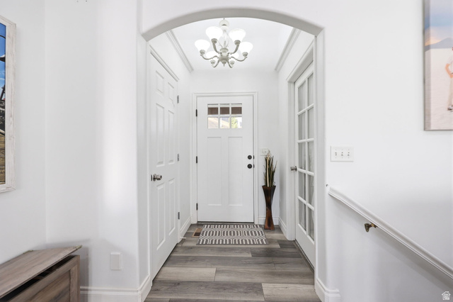 1816 River Bottom Road Springville, UT 84663 - Photo 4 of 37 Entryway featuring wood-finish flooring, a white paneled door with glass inserts, an arched architectural detail, a multi-bulb ceiling fixture, and a white interior door