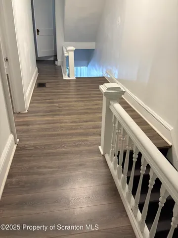 a view of entryway and hall with wooden floor