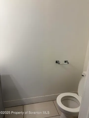 a view of kitchen with refrigerator and white cabinets