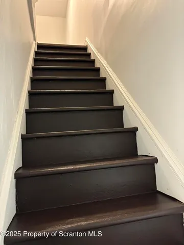 an empty room with wooden floor and entrance