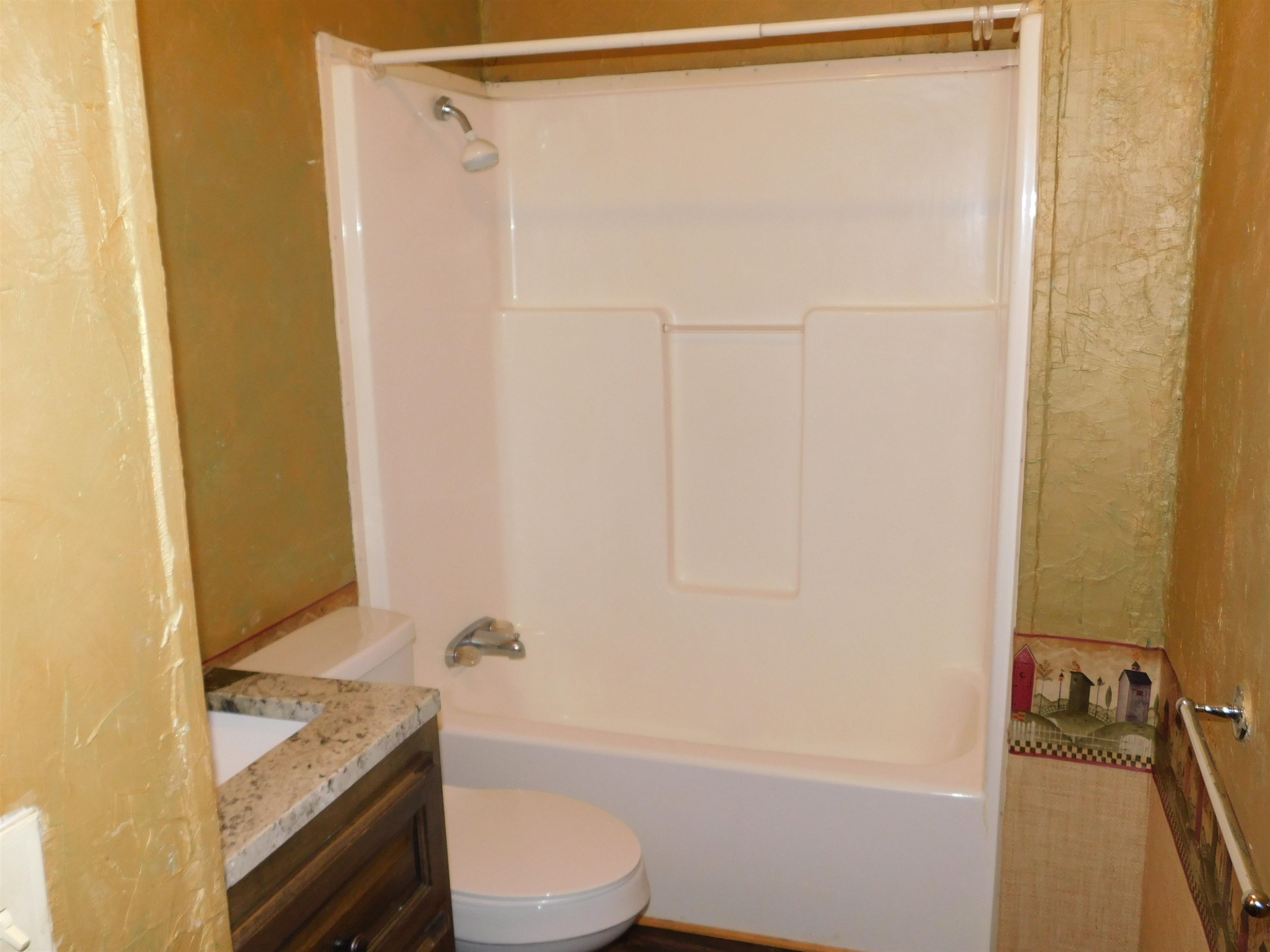 479 Fowler Road Beech Bluff, TN 38313 - Photo 16 of 18 a bathroom with a granite countertop bathtub shower sink vanity and toilet