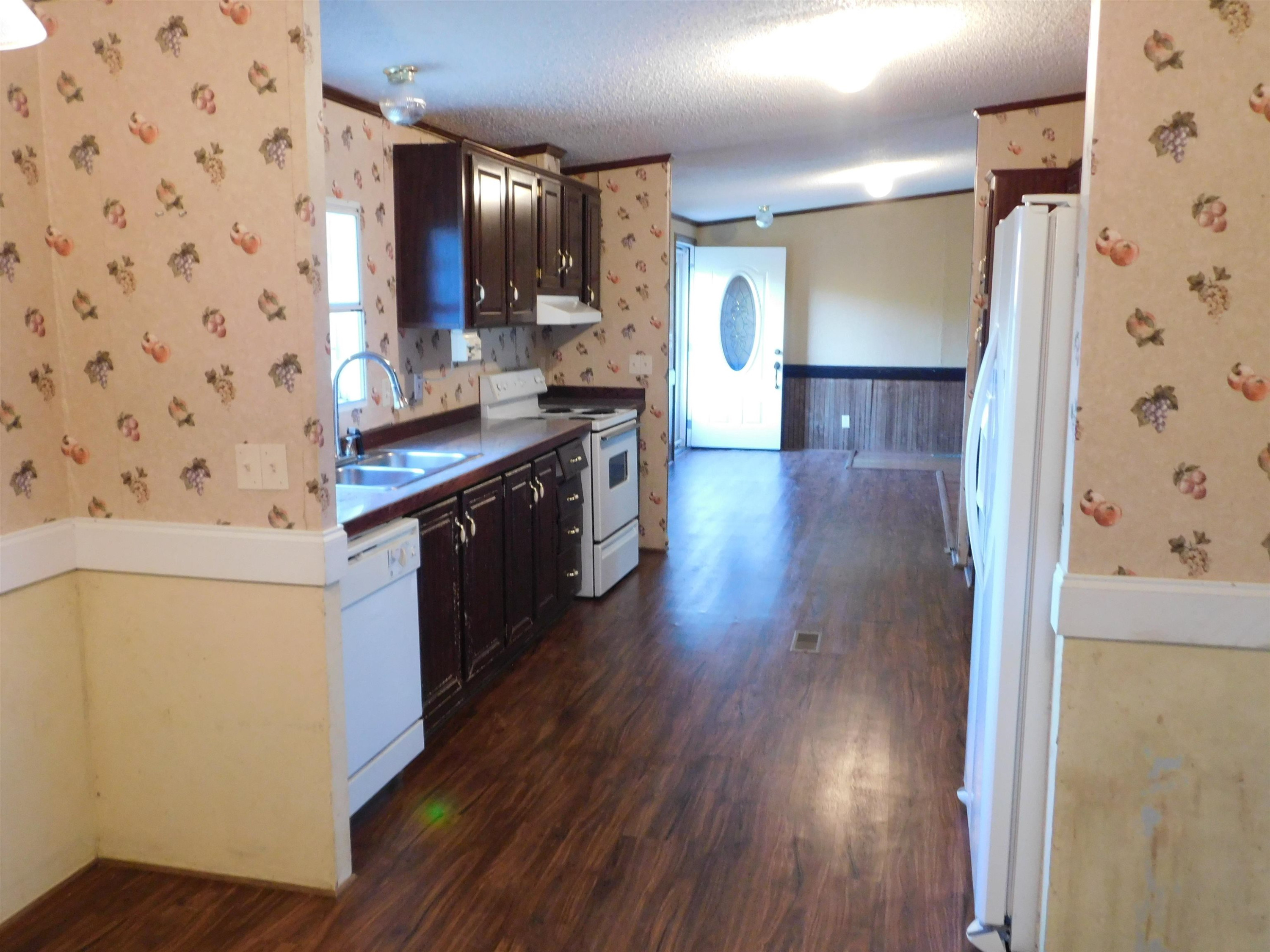 479 Fowler Road Beech Bluff, TN 38313 - Photo 8 of 18 a kitchen with stainless steel appliances a stove a refrigerator a sink and wooden floor
