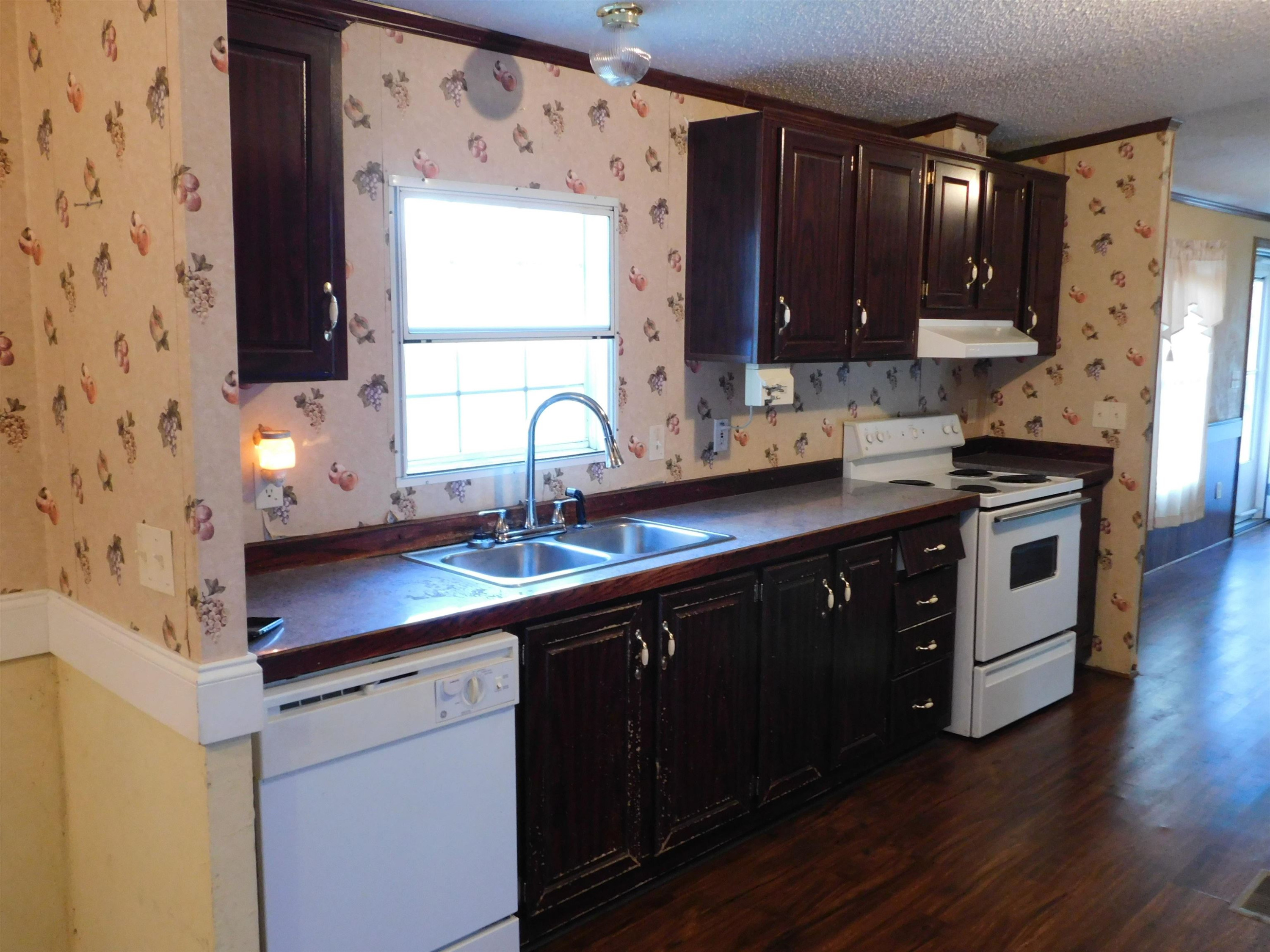 479 Fowler Road Beech Bluff, TN 38313 - Photo 9 of 18 a kitchen with stainless steel appliances a sink stove and wooden cabinets