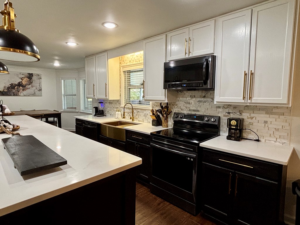 142 Gammage Road Eufaula, AL 36027 - Photo 35 of 47 a kitchen with a sink a stove a microwave and cabinets