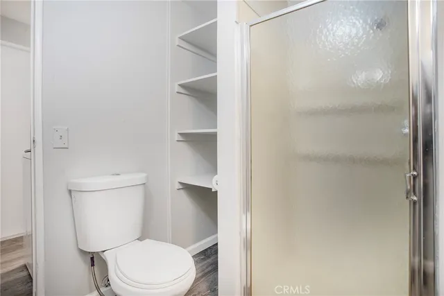 a white toilet sitting next to a shower
