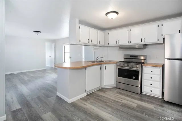 a kitchen with cabinets appliances and wooden floor
