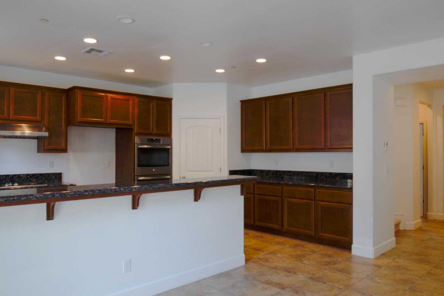 1817 Thomas Court Modesto, CA 95355 - Photo 6 of 20 a kitchen with stainless steel appliances granite countertop a stove a sink and a refrigerator