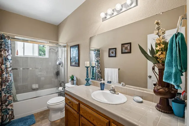a bathroom with a granite countertop sink a toilet and a mirror