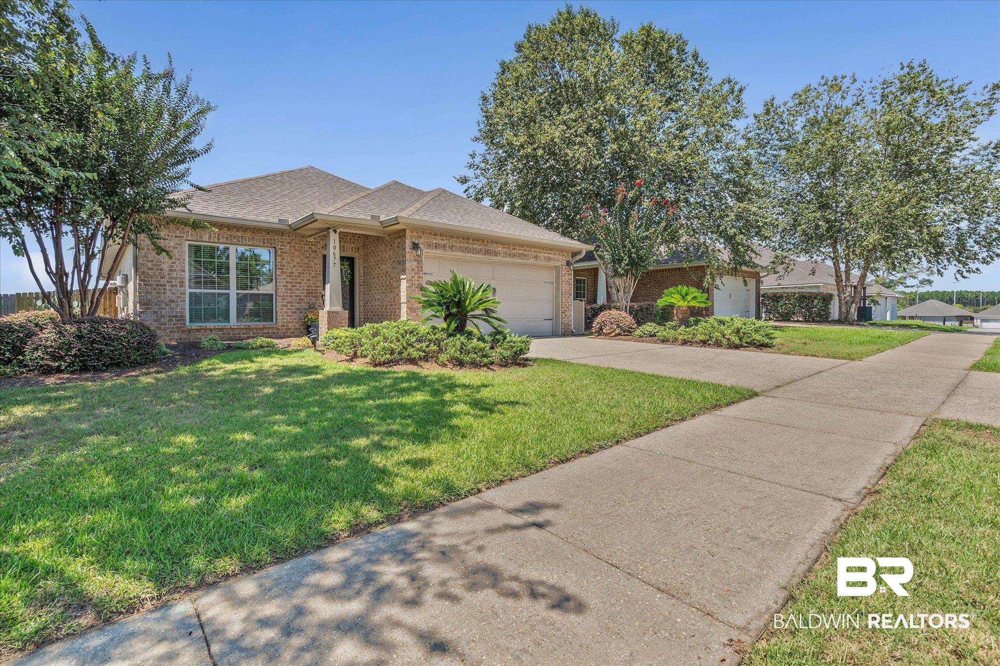 10677 Orkney Way Spanish Fort, AL 36527 - Photo 19 of 22 Ranch-style house with brick siding, a front lawn, an attached garage, concrete driveway, and roof with shingles