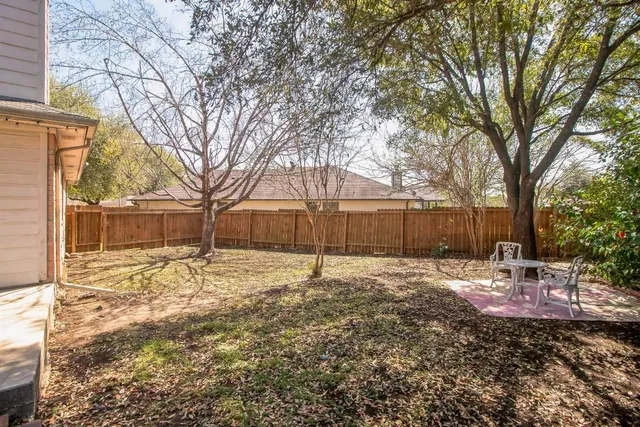 a backyard of a house with table and chairs