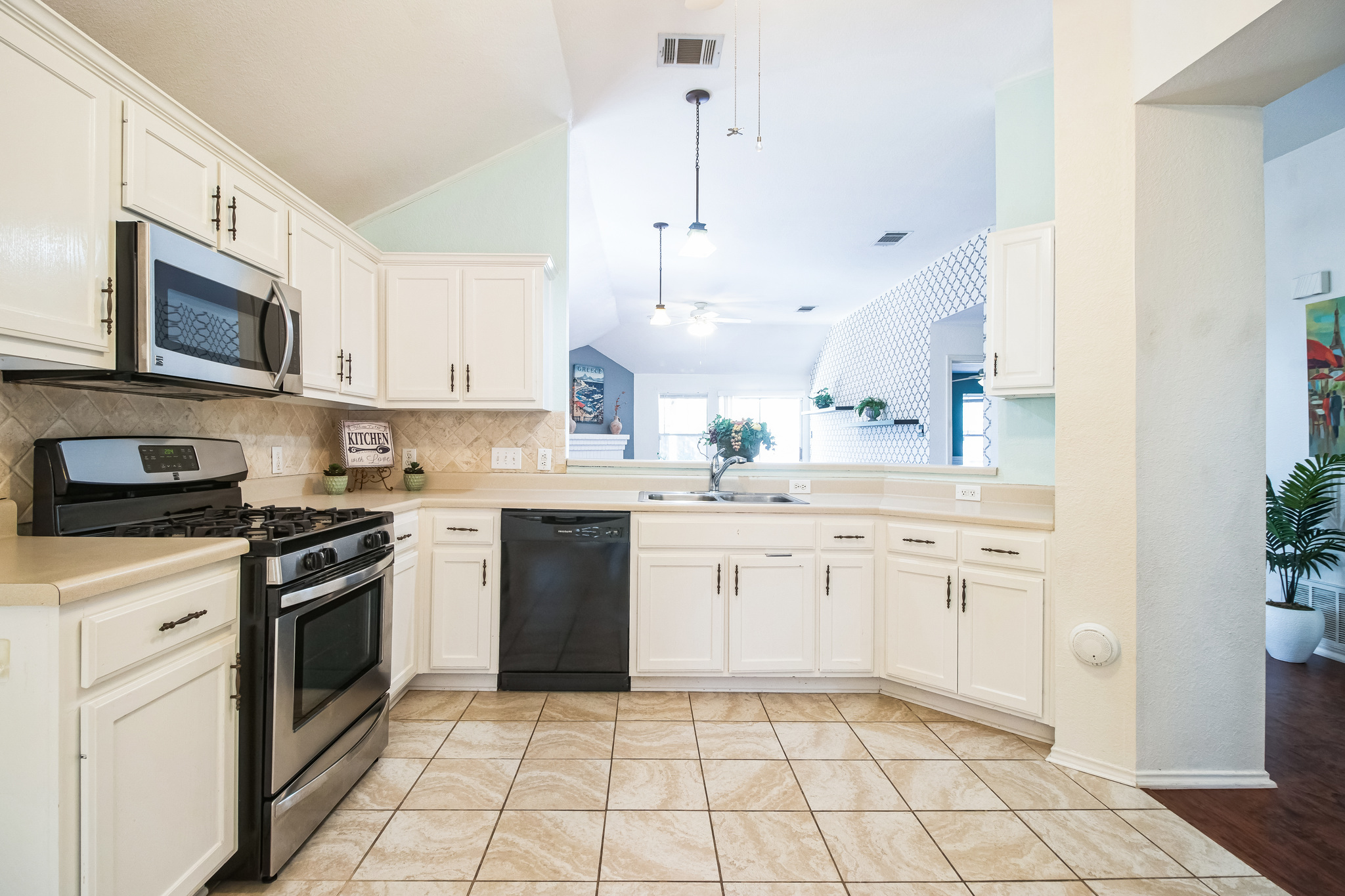 12316 Sugar Leaf Place Austin, TX 78748 - Photo 7 of 16 a kitchen with a stove a sink and a microwave
