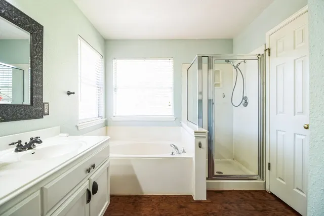 a bathroom with a tub sink shower and a mirror