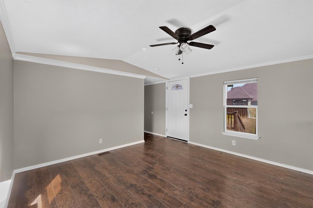 15281 Stice Road Krum, TX 76249 - Photo 7 of 22 Wood-finish flooring, neutral wall tones, crown molding, white trim, and a ceiling fan with integrated lighting