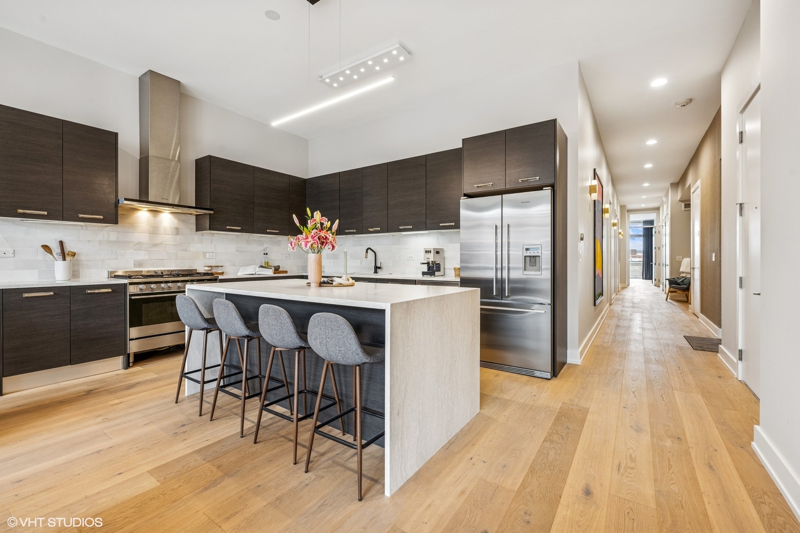 122 South Aberdeen Street, Unit 4S Chicago, IL 60607 - Photo 13 of 26 a kitchen with stainless steel appliances kitchen island granite countertop a table chairs refrigerator and microwave