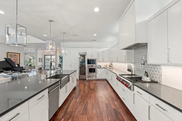 a large kitchen with kitchen island lots of counter space a sink and stainless steel appliances