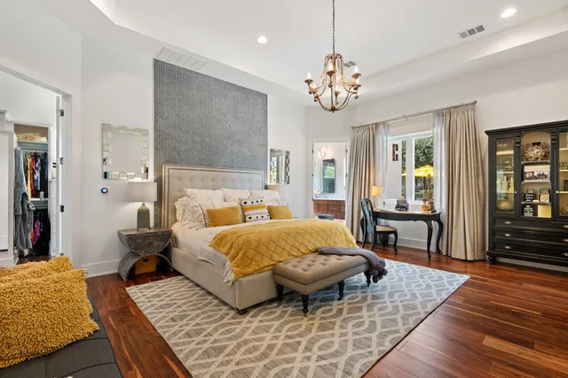 a spacious bedroom with a bed and wooden floor