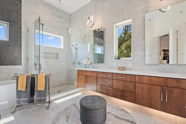 a spacious bathroom with a tub sink and mirror
