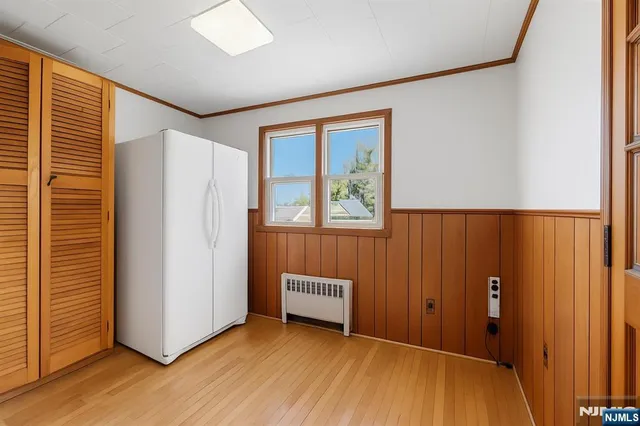 a view of a hallway with wooden floor and closet