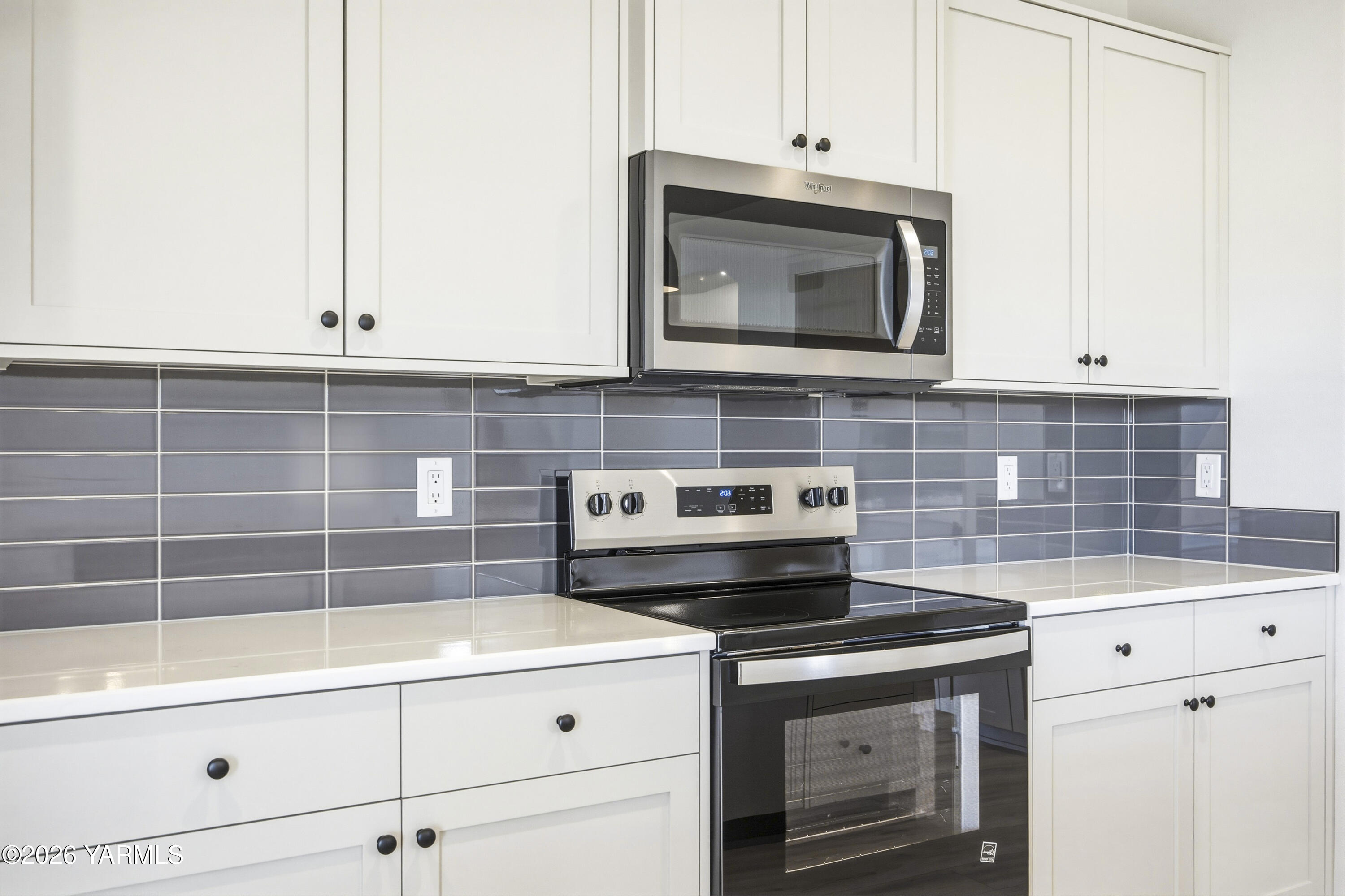 215 Packer Street Prosser, WA 99350 - Photo 43 of 45 a kitchen with granite countertop a stove top oven microwave and cabinets