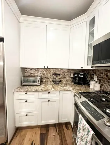 a kitchen with stainless steel appliances kitchen island granite countertop a refrigerator and a stove top oven