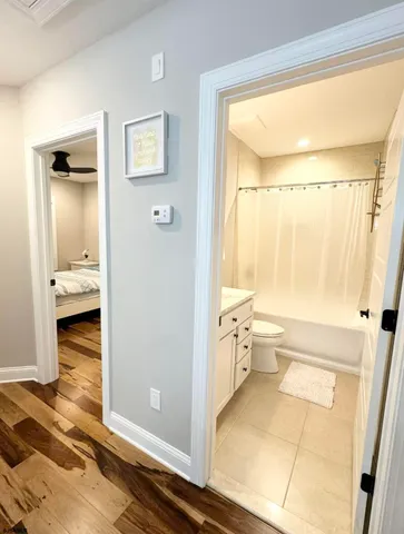 a bathroom with a sink vanity granite tub shower and a mirror