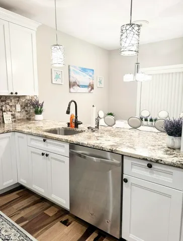 a kitchen with stainless steel appliances granite countertop a sink a stove and a microwave
