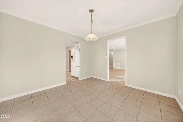 a view of an empty room with window and chandelier fan