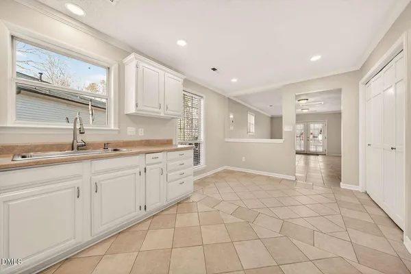 a large white kitchen with a sink and cabinets