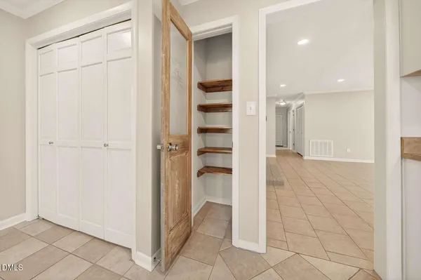 a view of a hallway with wooden shelves